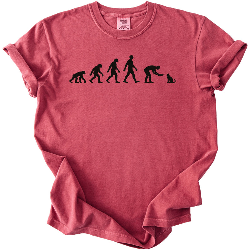 Red t-shirt with black graphic of human evolution ending with a person feeding a cat.