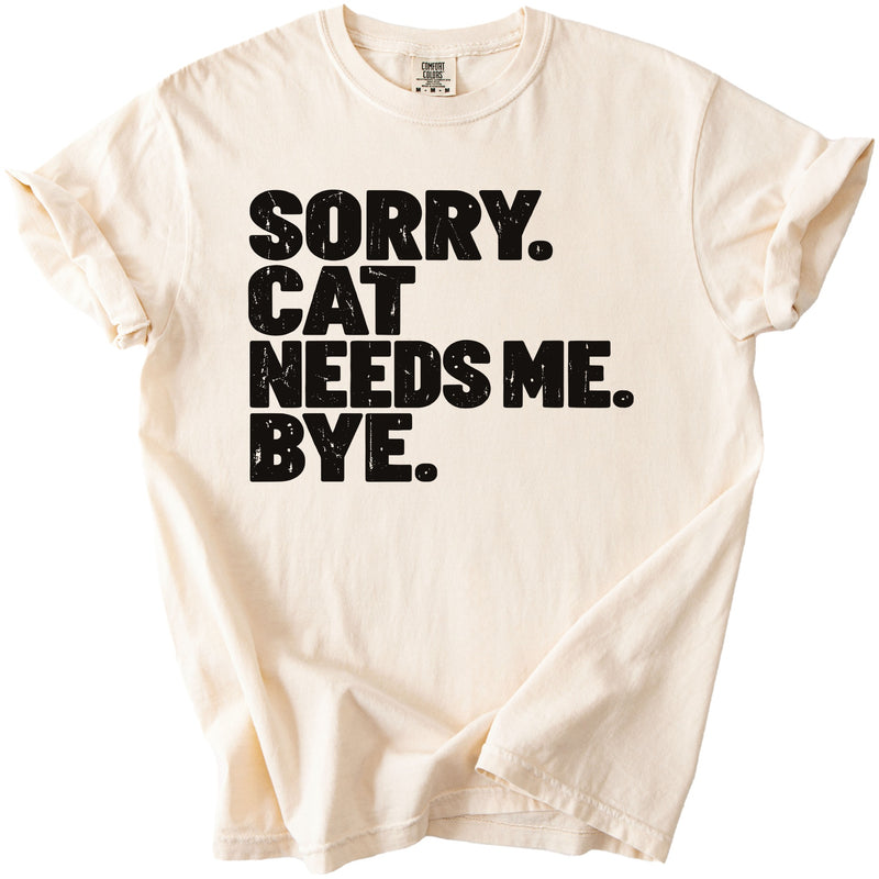 Light beige t-shirt with black text that reads "SORRY. CAT NEEDS ME. BYE."