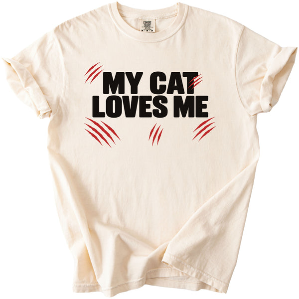 Cream t-shirt with black text "MY CAT LOVES ME" and red claw marks.