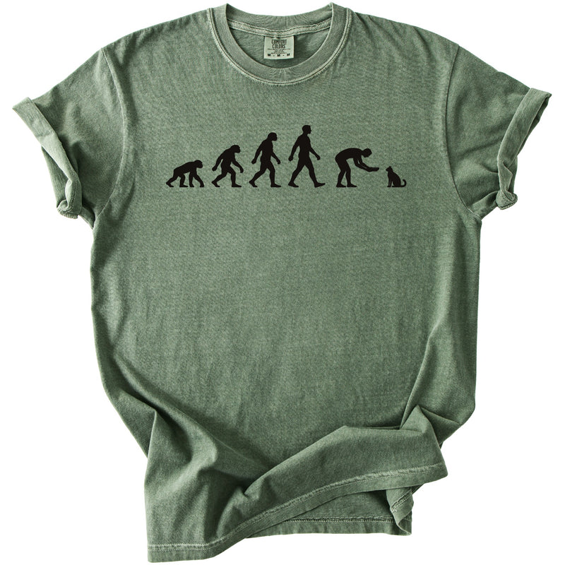 Green t-shirt with black graphic of human evolution ending with a person petting a cat.