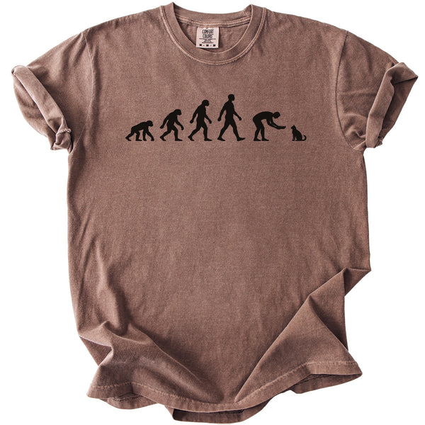 Brown t-shirt with black graphic of human evolution ending in a person petting a cat.