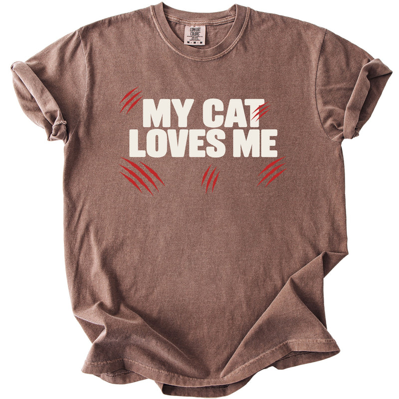 Brown t-shirt with white text "MY CAT LOVES ME" and red claw marks.