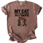 Brown t-shirt with black text and a cartoon cat wearing a red beret.