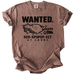 Brown t-shirt with black text "WANTED. SUS-SPSPSP-ECT AT LARGE" and a cat graphic.
