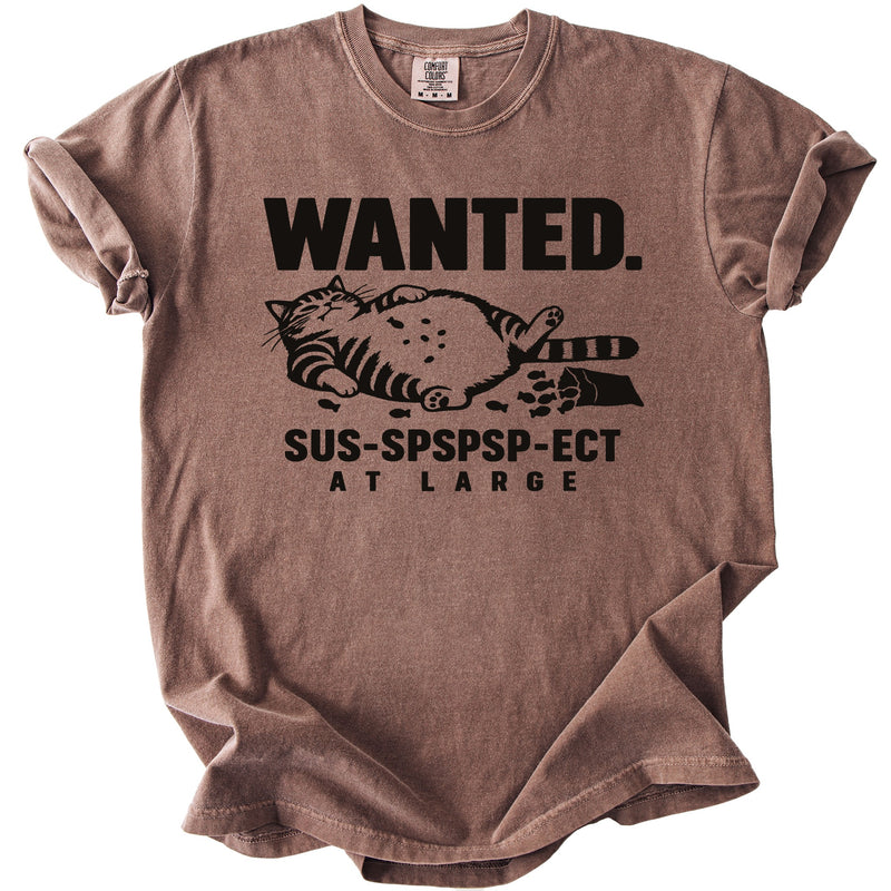 Brown t-shirt with black text "WANTED. SUS-SPSPSP-ECT AT LARGE" and a cat graphic.
