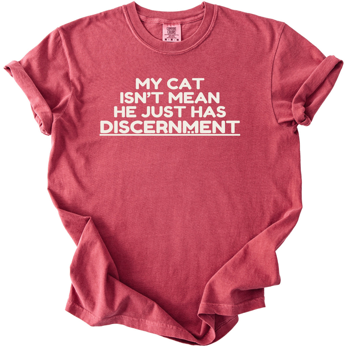 Red t-shirt with white text: "MY CAT ISN'T MEAN HE JUST HAS DISCERNMENT".