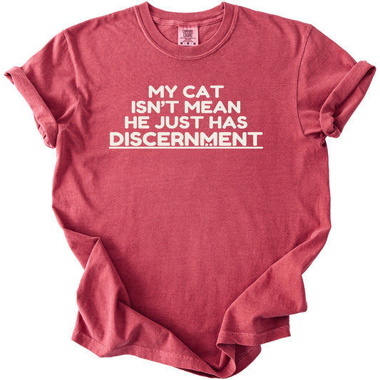 Red t-shirt with white text: "MY CAT ISN'T MEAN HE JUST HAS DISCERNMENT".