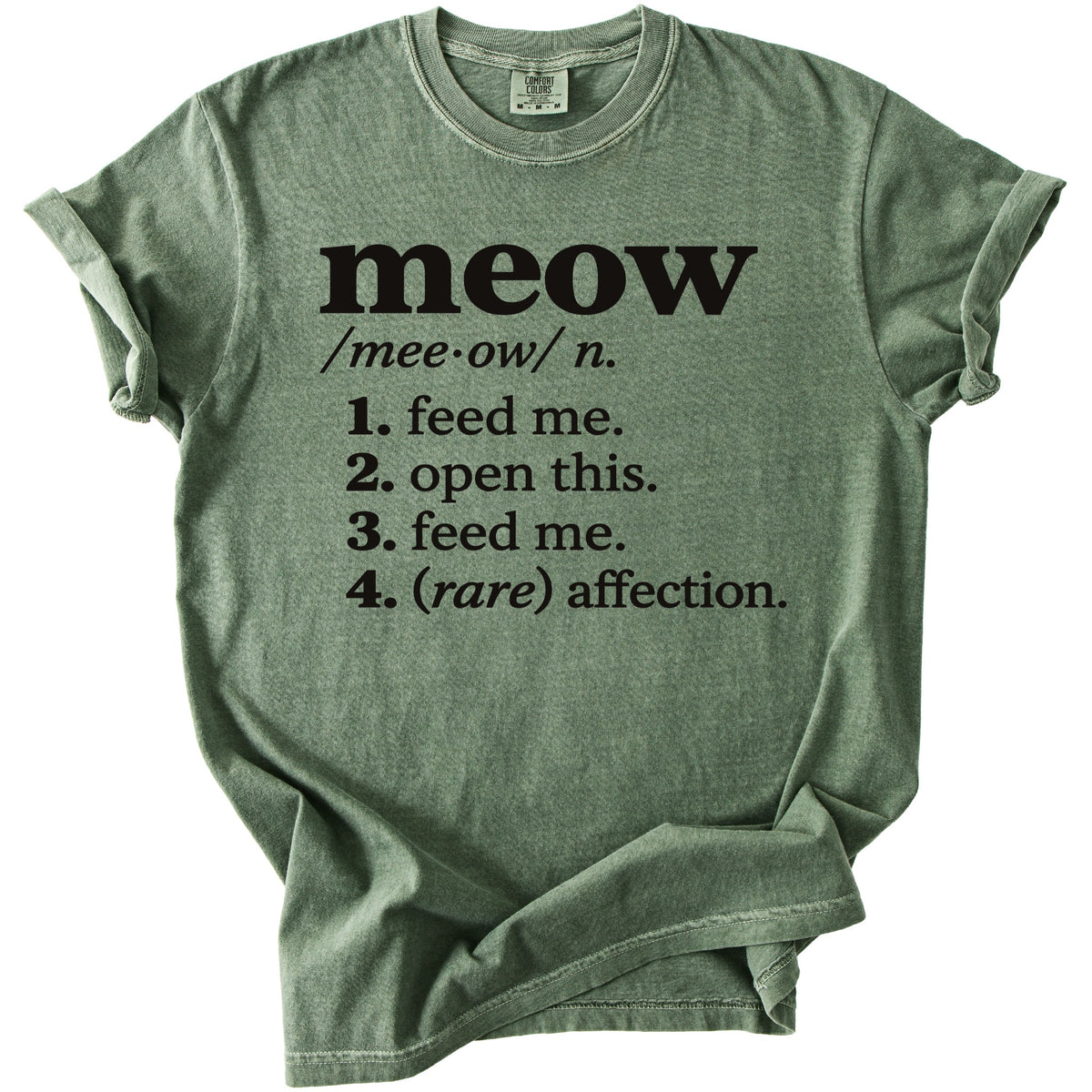 Green t-shirt with black text defining "meow" as "feed me, open this, feed me, (rare) affection."