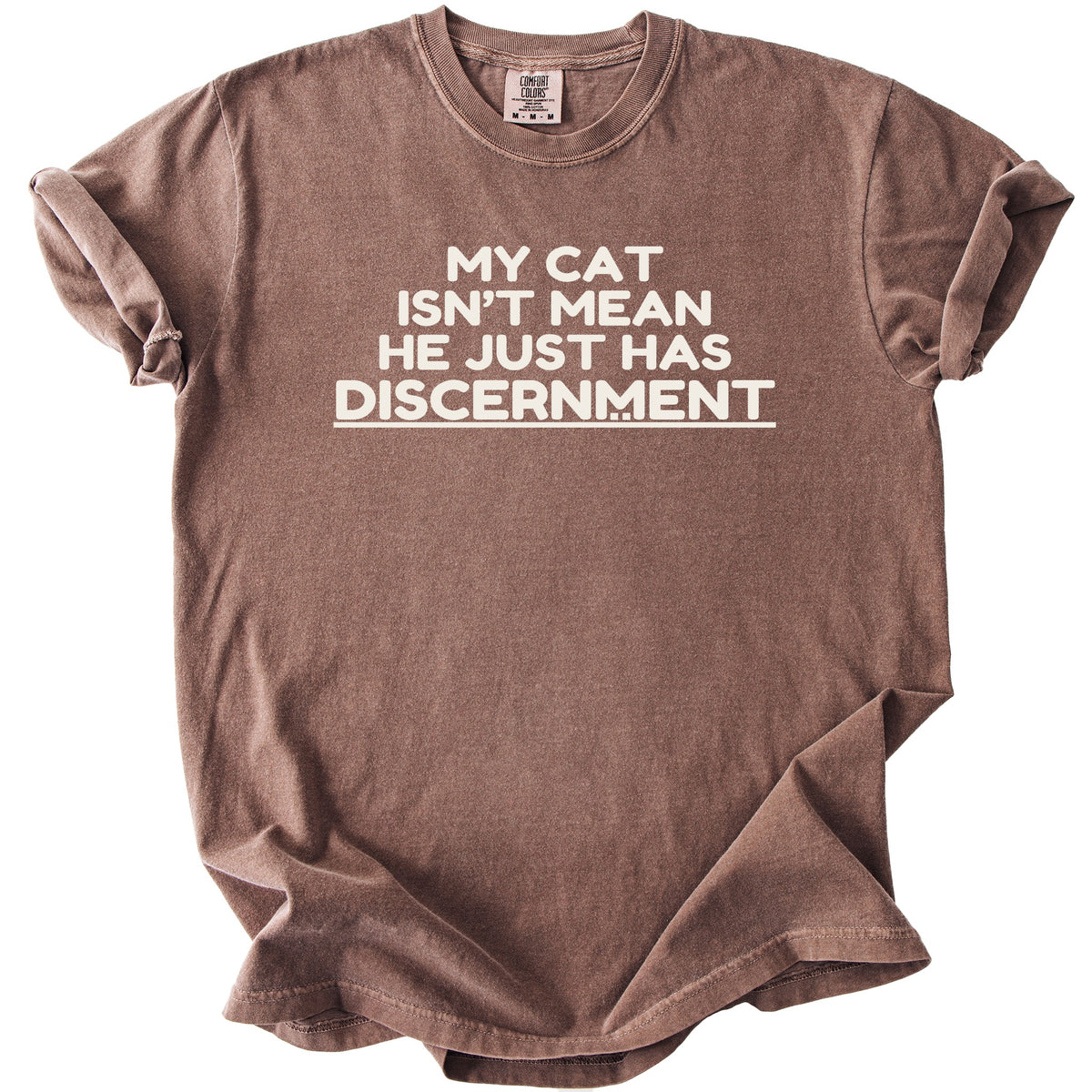 Brown t-shirt with white text: "My cat isn't mean he just has discernment."