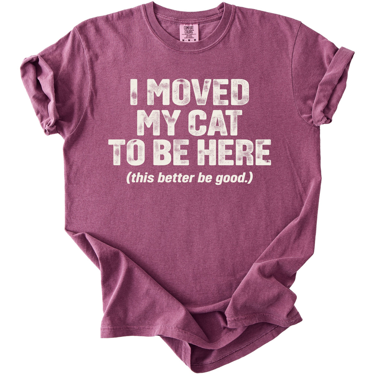 A plum-colored crewneck t-shirt with rolled sleeves features white distressed text that reads I moved my cat to be here (this better be good.).