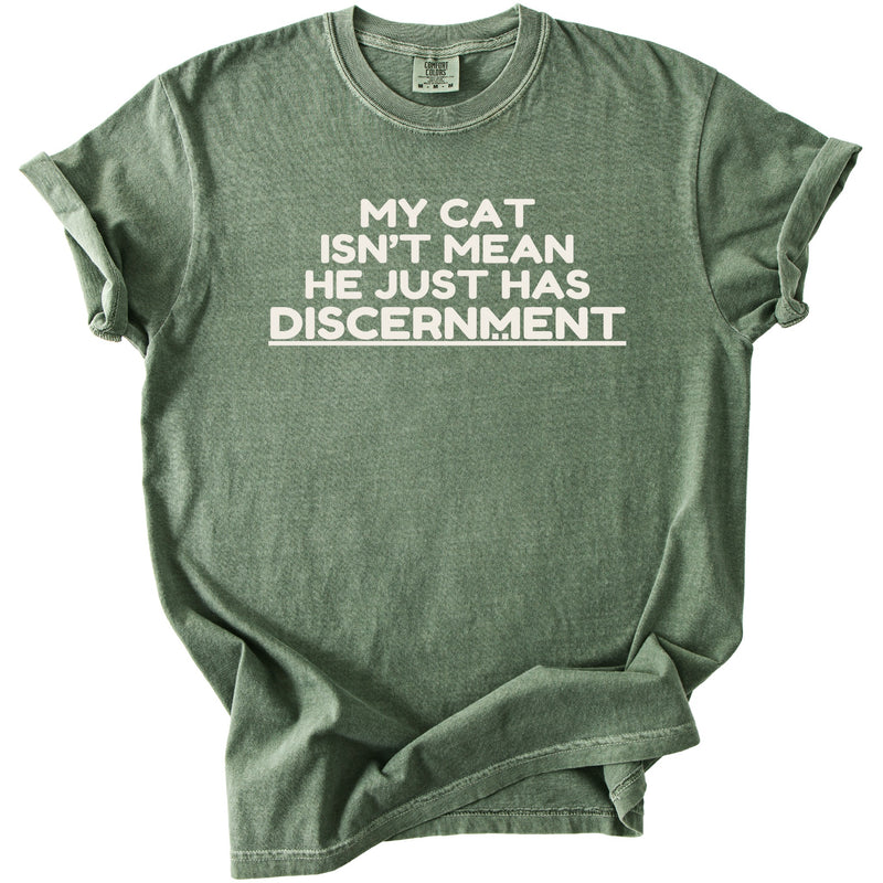 Green t-shirt with white text "MY CAT ISN'T MEAN HE JUST HAS DISCERNMENT".