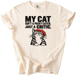 Cream t-shirt with text "MY CAT ISN'T A PICKY EATER. JUST A CRITIC." and cat illustration.