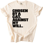 Light cream t-shirt with black text reading "CHOSEN BY A CAT. AGAINST MY WILL."