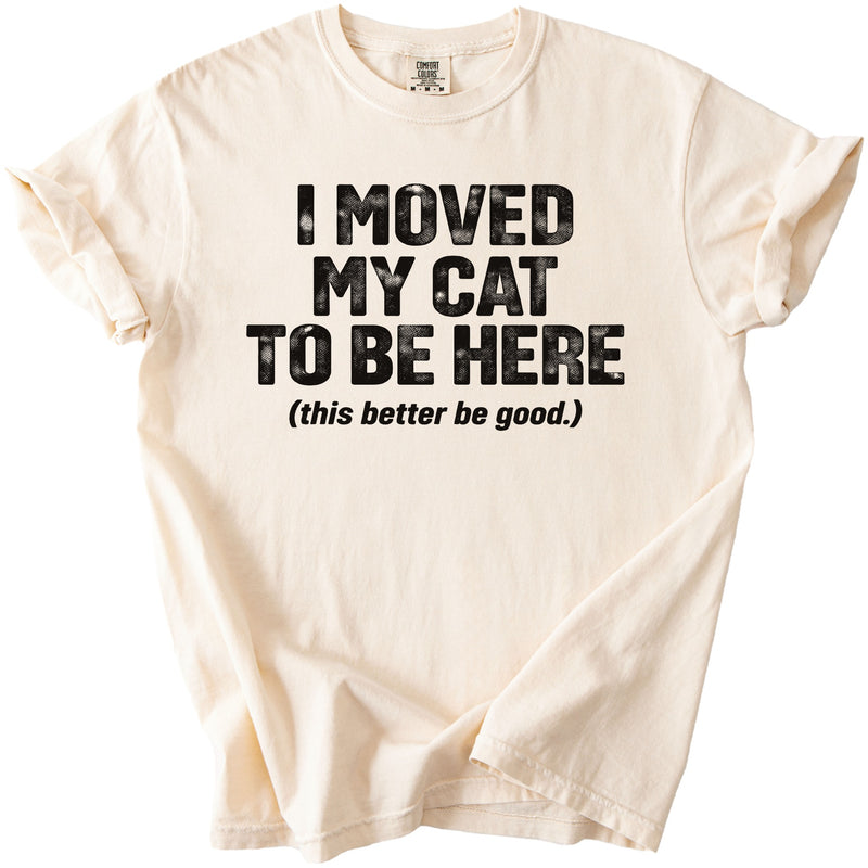 Cream t-shirt with black text reading "I MOVED MY CAT TO BE HERE (this better be good.)".