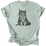 Line art tabby cat holding computer mouse and USB in mouth on light green t-shirt.