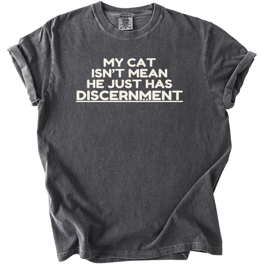 Dark grey t-shirt with white text reading "MY CAT ISN'T MEAN HE JUST HAS DISCERNMENT"