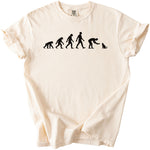 Cream t-shirt with black graphic of human evolution ending with a person feeding a cat.