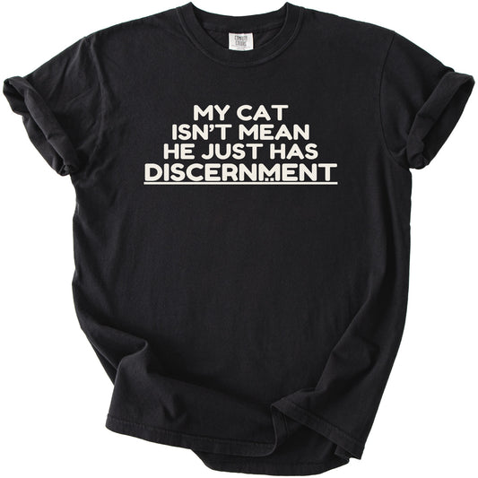 Black t-shirt with white text that reads "MY CAT ISN'T MEAN HE JUST HAS DISCERNMENT".