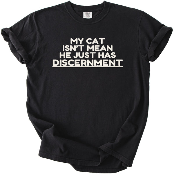 Black t-shirt with white text that reads "MY CAT ISN'T MEAN HE JUST HAS DISCERNMENT".